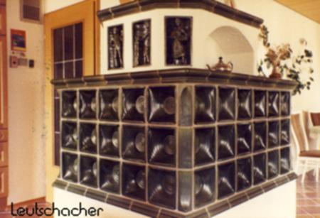 Bei diesem Kachelofen, der von der Firma Merx in Mühldorf mit Ofenkacheln von Leutschacher gebaut wurde, handelt es sich um einen Schüsselkachelofen mit plastisch modellierten Motivkacheln.