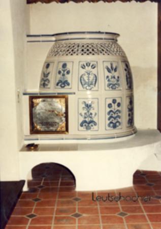 Bei diesem Kachelofen, der von der Firma Thaller in München mit Ofenkacheln von Leutschacher gebaut wurde, handelt es sich um einen traditionellen Ofen in Bienenkorbform.