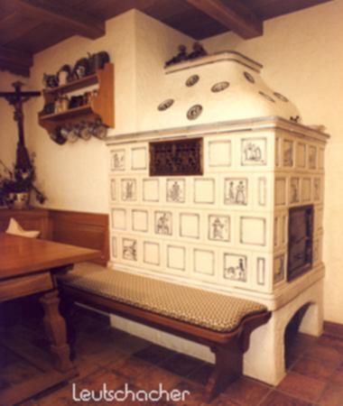 Bei diesem Kachelofen, der von der Firma Wolf in München mit Ofenkacheln von Leutschacher gebaut wurde, handelt es sich um einen Grundofen mit langer Speicherleistung.